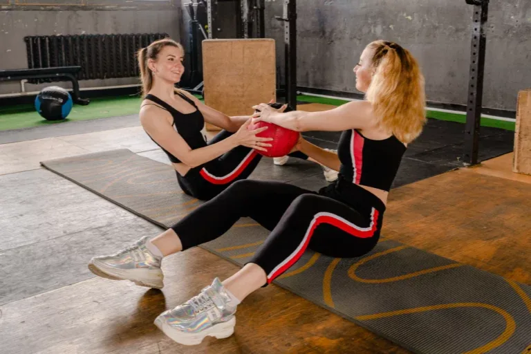 Een trainer begeleidt een sporter tijdens haar oefening