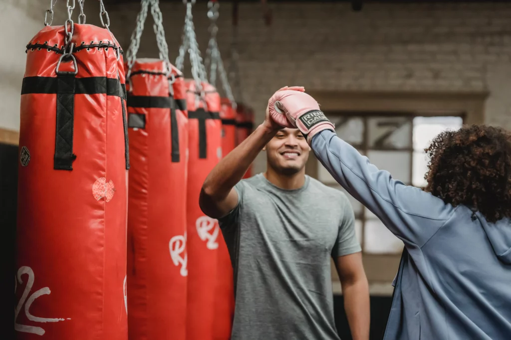 Een personal trainer die een van zijn leden een high five geeft na het afronden van een succesvolle training